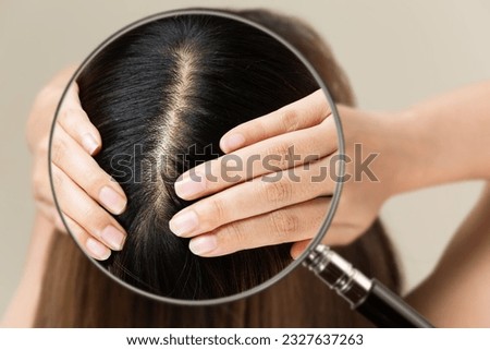 Enlarge a woman's scalp with a magnifying glass.