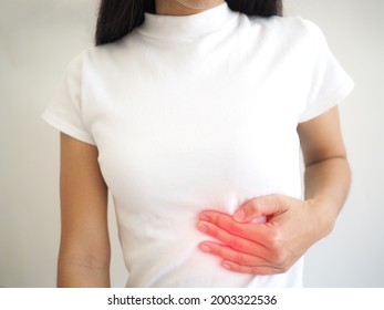 Enlarged Spleen In Women. She Touched Her Chest And Experienced Pain And Suffering. Health Care Concept. Closeup Photo, Blurred.