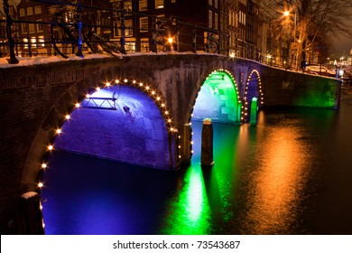 Enlightened bridge over canal in Amsterdam by night