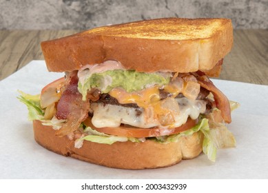 Enormous Texas Toast Sandwich Loaded With Hamburger, Cheese, Lettuce, Bacon, And Special Sauce For That Huge Appetite.