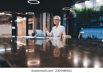 Enraged elderly businesswoman having conversation on video call mad about work issues while sitting in modern office during online meeting - Shutterstock ID 2301480421