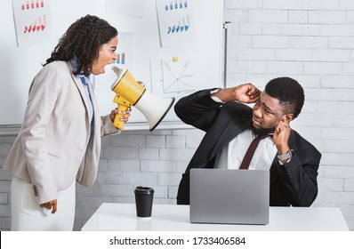 Enraged female boss with loudspeaker yelling at her subordinate in company office - Shutterstock ID 1733406584