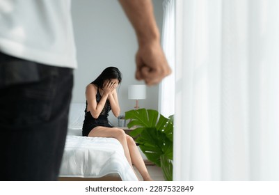 The enraged man tightened his hand to hit the frightened woman in the background. The concept of family and physical abuse - Shutterstock ID 2287532849
