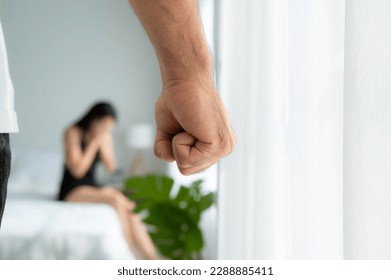The enraged man tightened his hand to hit the frightened woman in the background. The concept of family and physical abuse - Shutterstock ID 2288885411
