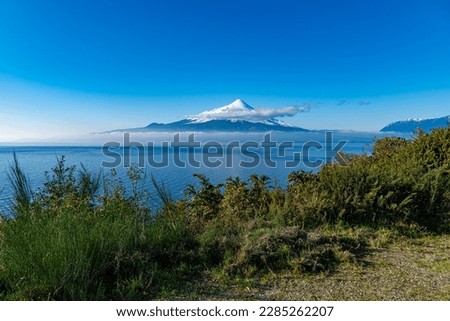 Ensenada, Los Lagos, Chile; august 10 2022: Photo of snowy Osorno volcano by the lake Llanquihue seen from the road to Ensenada on a sunny winter day, Chilean Patagonia