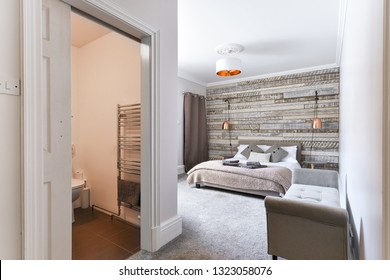 En-Suite Modern Bedroom With Rustic Wooden Headboard And White Linen And Pillows, Copper Lamp Shade - Airbnb Accommodation 