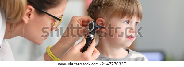 ENT doctor conducts physical examination of little\
girl ear