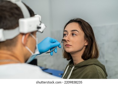 ENT Doctor Examines The Patient's Nose Using An Otoscope. Medical Examination Of The Nose. Healthcare And Medicine Concept.