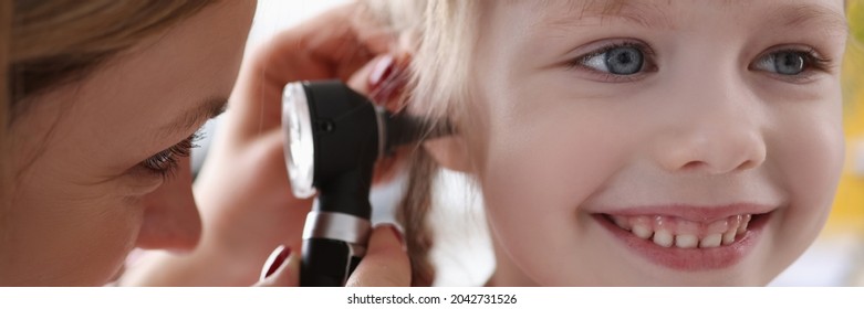 Ent Doctor Examining Sore Ear Of Small Child Using Otoscope