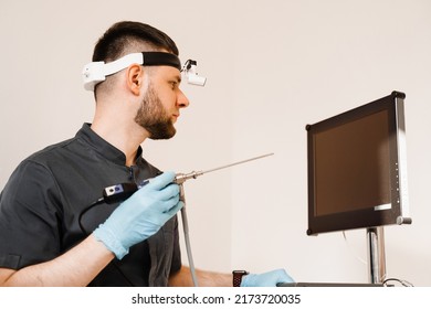 ENT Doctor Otolaryngologist With Endoscope In Hands. Prepearing For Endoscopy Procedure. Doctor With Headlight