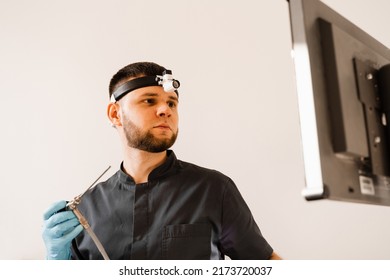 ENT Doctor Otolaryngologist With Endoscope In Hands. Prepearing For Endoscopy Procedure. Doctor With Headlight