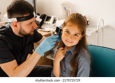 ENT Doctor Otolaryngologist Looks Through Otoscope The Ears Of A Little Girl. Otoscopy. Treatment Child Ear Pain