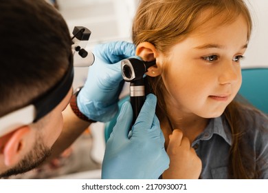 ENT Doctor Otolaryngologist Looks Through Otoscope The Ears Of A Little Girl. Otoscopy. Treatment Child Ear Pain
