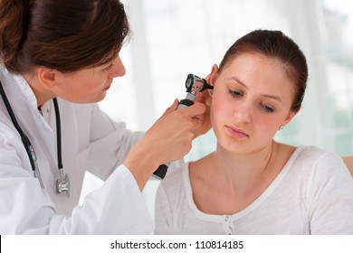 ENT physician looking into patient's ear with an instrument - Powered by Shutterstock