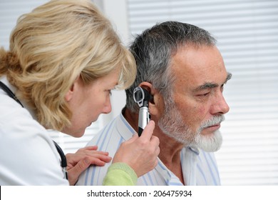 ENT physician looking into patient's ear with an instrument - Powered by Shutterstock