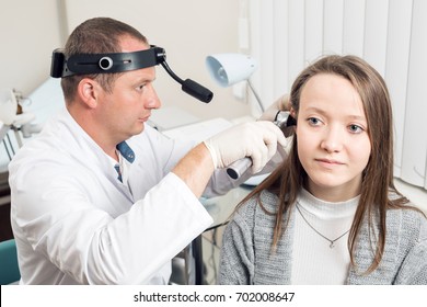 ENT physician looking into patient's ear with an instrument. private clinic. otolaryngologist