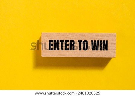 Enter to win message written on single wooden block with yellow background. Conceptual enter to win symbol. Copy space.