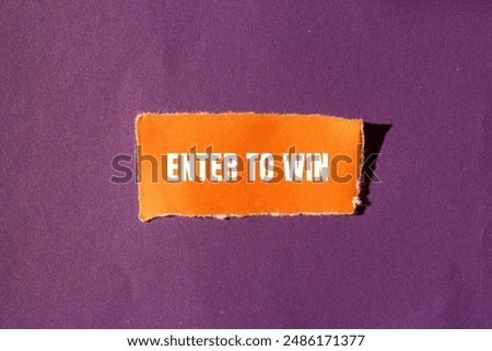 Enter to win message written on ripped torn orange paper piece with purple background. Conceptual enter to win symbol. Copy space.