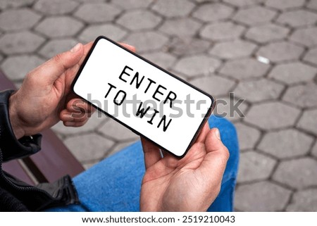 Enter to win message written on smartphone screen. Conceptual enter to win symbol. Copy space.