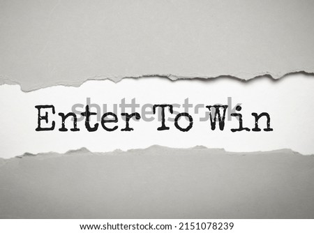 Enter to win text on paper. Word Enter to win on torn paper. Concept Image