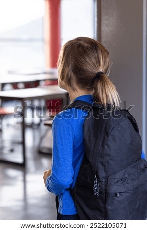 Entering classroom, boy with backpack looking inside, ready for school day. Education, back to school, learning, student, elementary, preparation