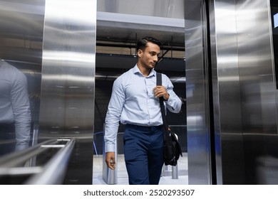 Entering elevator, businessman carrying shoulder bag, heading to office work. corporate, professional, executive, commute, briefcase, career - Powered by Shutterstock