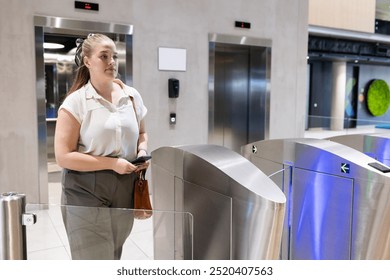 Entering office building, woman using access card at security turnstile. Business, corporate, technology, workplace, ID card, entrance - Powered by Shutterstock