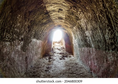 Entering onto light from underground cells of Buddhist monks on hill of Kara Tepe, Termez, Uzbekistan. Settlement existed in 1st-5th centuries AD. Original paint color (red) can still be seen on walls - Powered by Shutterstock