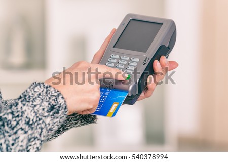 Entering PIN code on wireless payment terminal with inserted redit or debit card