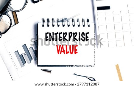 Enterprise value concept with notebook, financial charts, calculator and office supplies on desk, representing company valuation. 