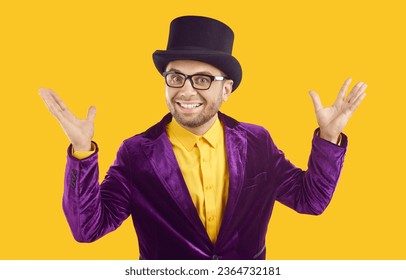 Entertainer presents new holiday circus show program. Man wearing purple velvet suit and tophat spreads hands, smiles and looks at camera with happy funny face expression isolated on yellow background - Powered by Shutterstock