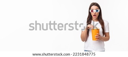 Entertainment, fun and holidays concept. Portrait of gasping amazed and startled young woman watching interesting thrilled in cinema, enjoying cool movie, eating popcorn, wear 3d glasses.
