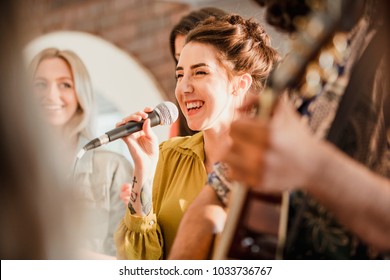 Entertianment at a wedding. A female singer is interacting with the crowd while a man plays an acoustic guitar.  - Powered by Shutterstock