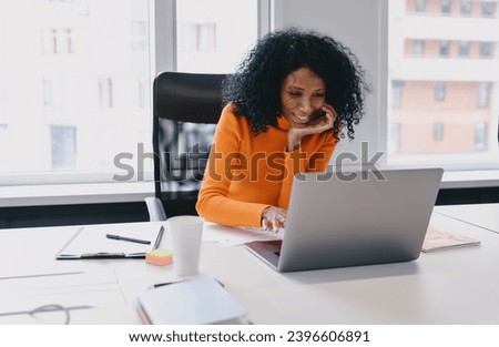 Enthusiastic African American content creator in her 30s crafting digital media strategies on her laptop