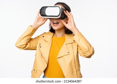 Enthusiastic Asian Girl In VR Glasses, Looking With Virtual Reality Headset At Smth Amazing, Standing Over White Background