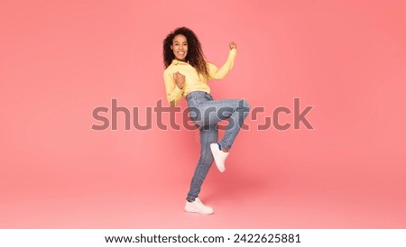 Enthusiastic black woman in excitement clenches her fists and gestures yes against vibrant pink background, ideal for showcasing positivity, success and enthusiasm, full length