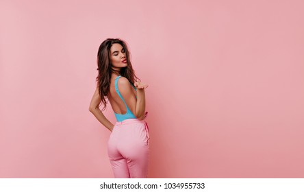 Enthusiastic Brown-haired Girl Wears Cute Attire Looking Over Shoulder With Smile. Romantic Female Model With Dark Long Hairstyle Posing In Studio.