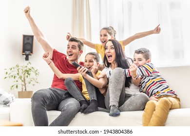 Enthusiastic family of five cheers at home watching sports on TV 
