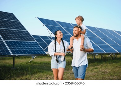 Enthusiastic father showing potential of alternative energy. Contemporary family looking at new solar station they bought. Side view of happy parents and interested child next to solar panels. - Powered by Shutterstock