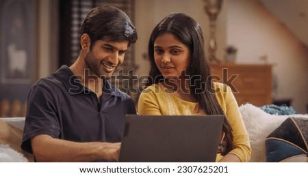 Enthusiastic Indian couple browsing online stores for fashionable outfits, latest electronics, or exclusive travel offers. Sharing quality time while exploring new hobbies and home décor items.