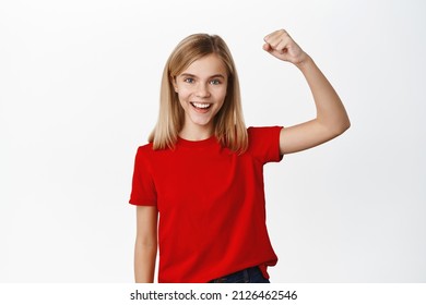 Enthusiastic Little Blond Girl, Teen Chanting With Fist Pump, Screaming And Rooting For Team, Being An Activist, Standing In Red T-shirt Over White Background