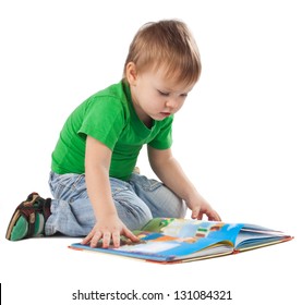 Enthusiastic little boy with a book sitting on the floor, isolated on white