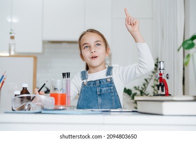 Enthusiastic Little Girl Doing Home Science Project, Having A Eureka Moment. She Has Chemistry Glassware With Colorful Liquids And Microscope