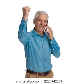 Enthusiastic Old Guy Talking On The Phone And Celebrating Victory With Fist Up In Front Of White Background In Studio, Smiling