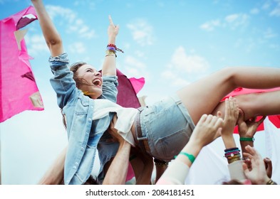 Enthusiastic woman crowd surfing at music festival - Powered by Shutterstock