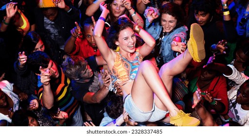 Enthusiastic woman crowd surfing at music festival - Powered by Shutterstock