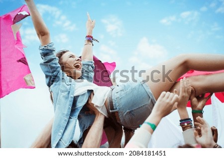 Enthusiastic woman crowd surfing at music festival