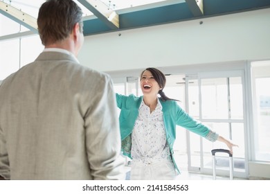 Enthusiastic woman greeting man in airport - Powered by Shutterstock