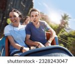 Enthusiastic young couple screaming on amusement park ride