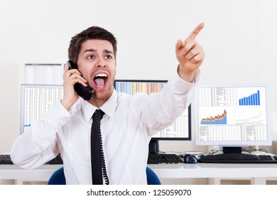 Enthusiastic Young Male Stock Broker In A Bull Market Holding A Telephone And Yelling Out A Buy Or Sell Order On Stocks Or Bonds